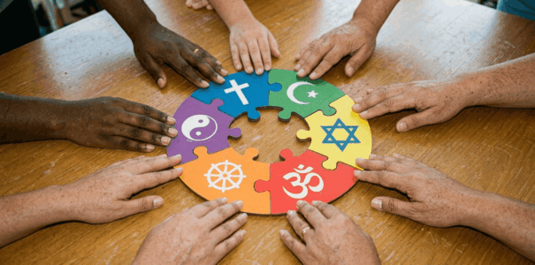 hands putting together religious puzzle pieces