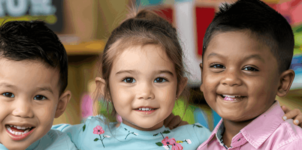 3 young kids smiling at the camera